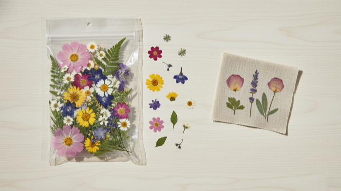 Dried Flower Kit and Sample Opened dried flower craft kit with finished botanical textile sample on linen.